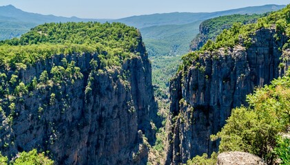 Fototapeta premium Antalya, Turkey - July 15, 2026: View of Tazy Canyon in Antalya, Turkey, showing dramatic rocky cliffs, deep canyon landscape, green forested slopes, natural rock formations, and scenic views