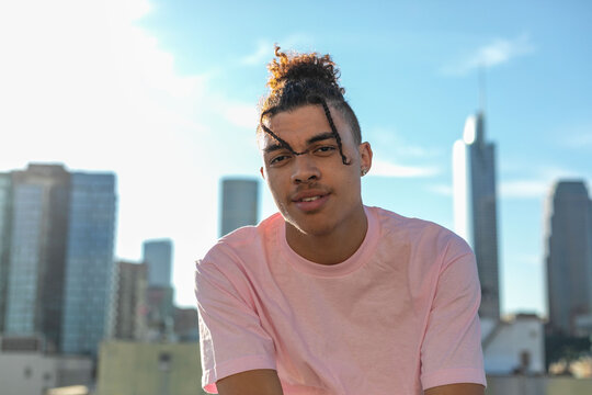 Person in a pink shirt with a city skyline in the background.