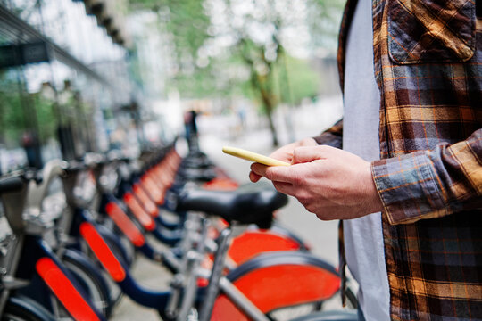 Young man using smart phone at bicycle parking station