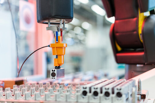 Arm of assembly robot picking up machine part, Stuttgart, Germany