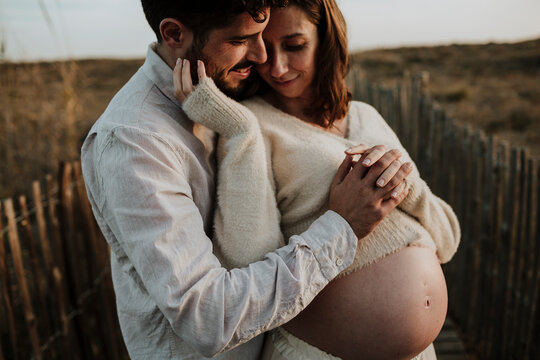 Expectant couple sharing an intimate moment outdoors
