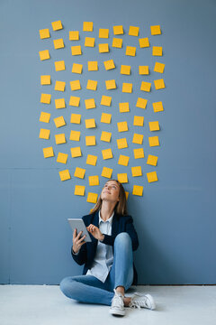 Young businesswoman usig digital tabet, sitting under data cloud