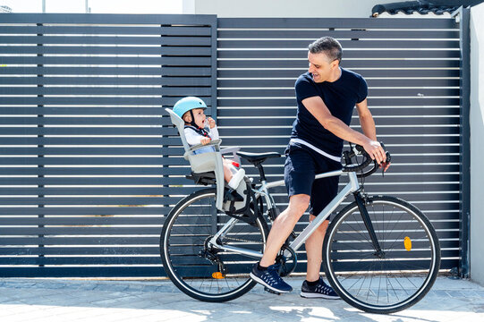 Father with son sitting in safety seat of bicycle