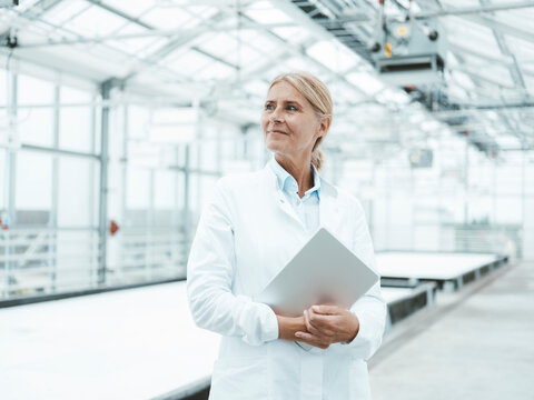 Thoughtful scientist with tablet PC in industry