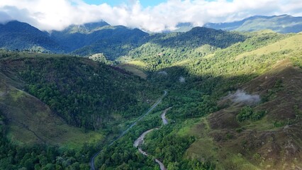Aerial View of Winding River Through Tropical Mountain Valley with Lush Rainforest © Alsy