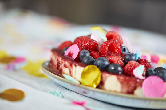Birthday cake with berries on table