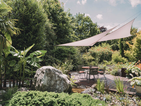 Peaceful backyard patio with sun sail and outdoor dining area