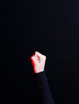 Raised fist in black sleeve showing power and protest