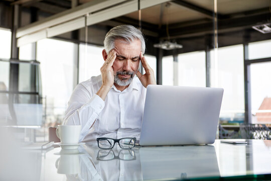 Businessman with headaches sitting at desk in office