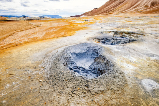 Grey mud pot bubbles in the Hverir geothermal area of Iceland