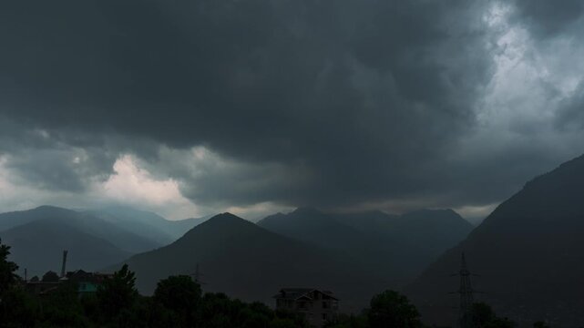 4K Timelapse of dark stormy clouds moving over mountains and monsoon rain falling. Stormy sky during heavy rainstorm in Manali, Himachal Pradesh, India. Weather in rainy season.