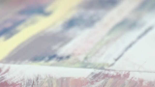 Fingers dance over colorful strokes on canvas. Artist's passion shines as textures and hues blend seamlessly, capturing emotions in every brush movement. This close-up reveals beauty of creativity.