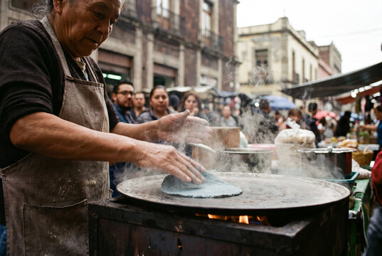 Street food vendor in Mexico City making fresh corn tortillas on a comal