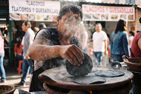 Street food vendor in Mexico City making fresh corn tortillas on a comal