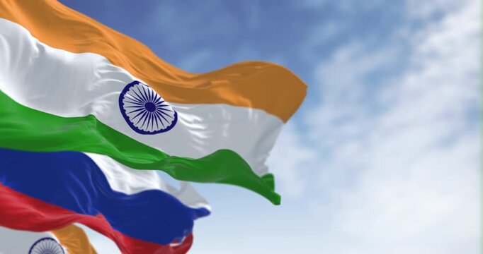 The flags of India and Russia waving in the wind on a clear day