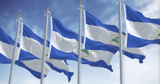 Nicaraguan national flags waving with coat of arms and blue-white tricolor