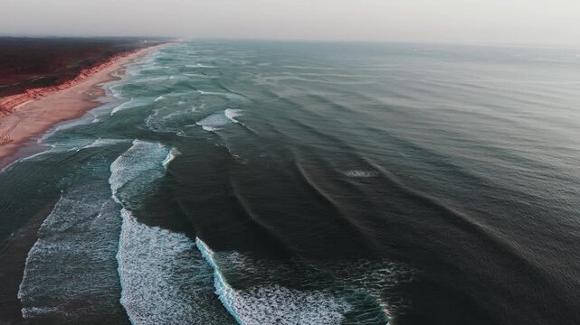 Ocean waves breaking along wide sandy shoreline at Sao Pedro de Maceda on Atlantic coast of Portugal