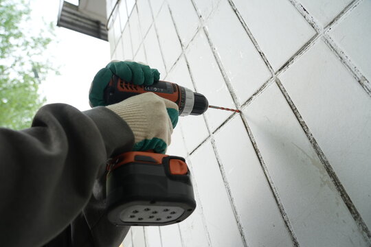 Low angle view of drilling tiled facade close-up