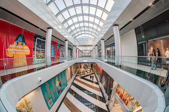 Multi-level, symmetrical shopping center Blockbuster Mall in Kyiv Domed ceiling with translucent panels, vibrant banner decorations, and repeating floor pattern - Kyiv, Ukraine 06-15-2025