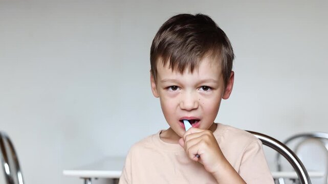 Slow motion shows autistic boy learning to brush teeth by himself. Child practices dental care during challenging process. gag reflex in a child while brushing teeth