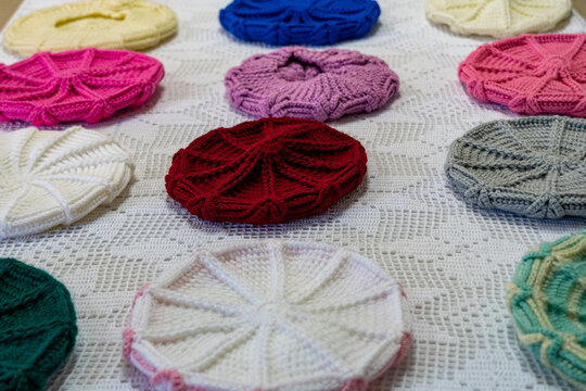 Crocheted berets featuring raised geometric patterns and a variety of vibrant colors.