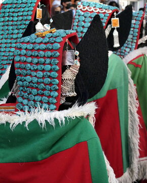 Women wearing traditional Ladakhi perak headdresses decorated with turquoise stones during a festival in Leh