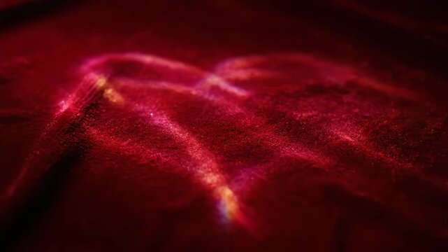 Abstract macro close-up of dark red shimmering particulate texture or luxurious velvet fabric background with deep folds, emphasizing richness and dramatic lighting.