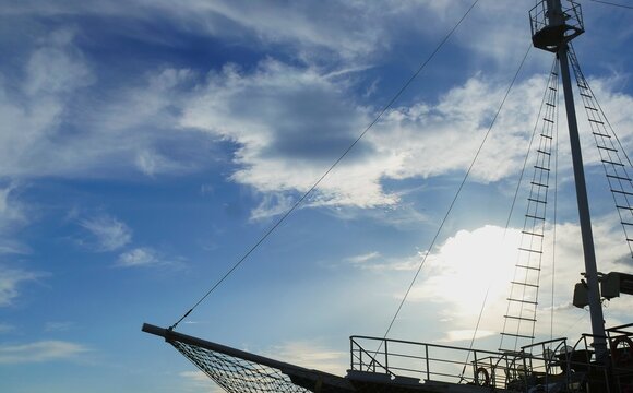 Sailing boat on the sea high in the blue sky with fluffy white clouds, nautical sea transport background