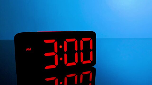Digital alarm clock changing from 2:59 am to 3:00 am with red led display