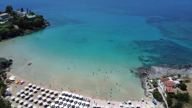 Drone footage of Kalogria Beach near Stoupa in Mani, Greece, featuring crystal-clear turquoise waters, a sandy beach, and the beautiful Mediterranean coastline on a sunny summer day.