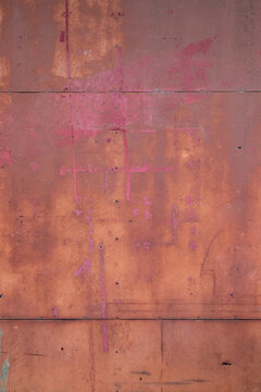 A weathered and textured background of a rusty red metal panel wall featuring corrosion, metal joints, fasteners, and abstract markings, ideal for design, background, and 3D rendering textures.