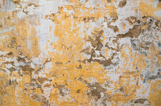 A rustic and weathered background of an old wall featuring peeling yellow and white paint, cracked plaster, and exposed cement, ideal for architectural designs, vintage backdrops, and 3D rendering.