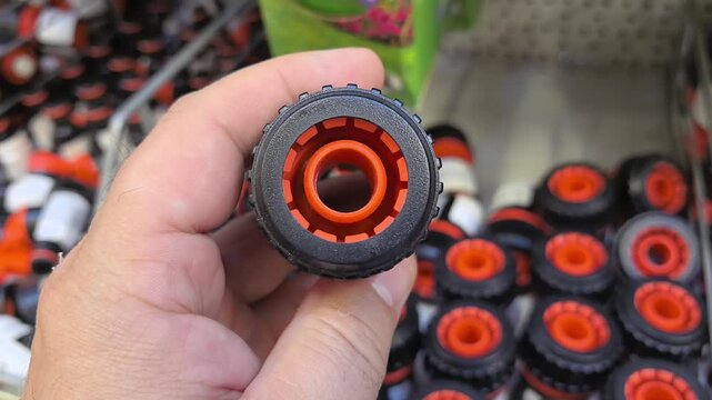 This clip showcases the unique design of a water hose transition fitting in a busy garden supply store.