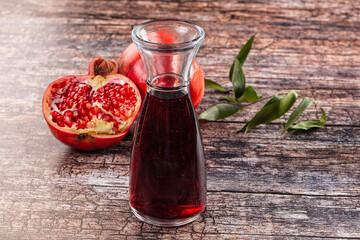 Pomegranate juice in glass carafe with fresh ripe fruit on rustic wooden table © Andrei Starostin