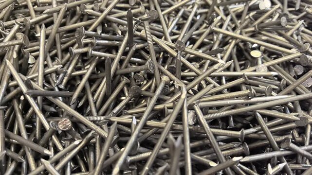 A close look at a box filled with countless nails showcasing their varied shapes and sizes. Each nail tells a story of craftsmanship and potential projects waiting to unfold.