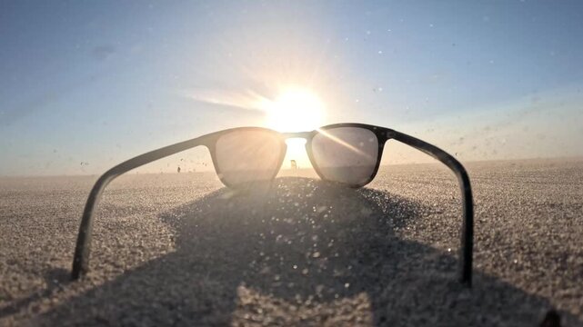 Cinematic golden hour at Kijkduin Beach showcasing sunglasses, drifting sand and distant kitesurfers beneath a glowing sky