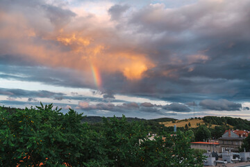 Rainbow on a stormy sky, with wind turbines and a GSM mast in the background, Kamienna Góra, Poland. © stockcrafter