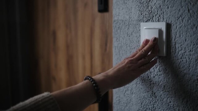 Female Hand Insistently Rings The Doorbell Over And Over Into The Apartment's Front Door