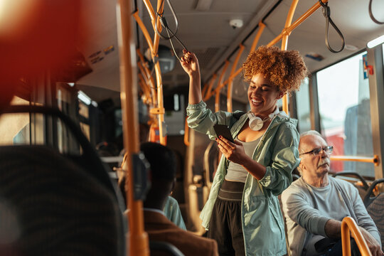 Young woman enjoying bus ride using smartphone