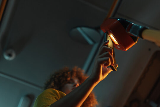 Woman paying for public transport using smartphone tapping validator