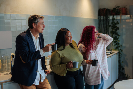 Diverse colleagues drinking coffee enjoying an office break