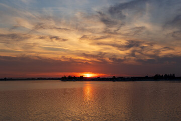 Obraz premium Vibrant sunset reflecting on the water of Lake Morii in Bucharest, Romania