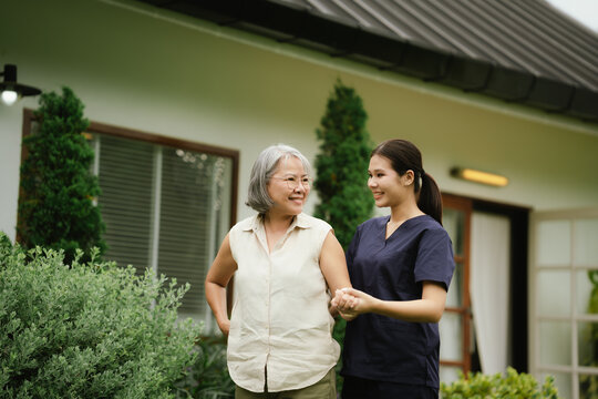 Professional caregiver assisting a senior woman during an outdoor walk, promoting mobility, balance, confidence, and independent aging.