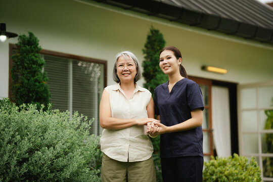 Professional caregiver assisting a senior woman during an outdoor walk, promoting mobility, balance, confidence, and independent aging.