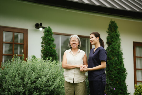 Professional caregiver assisting a senior woman during an outdoor walk, promoting mobility, balance, confidence, and independent aging.