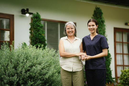 Professional caregiver assisting a senior woman during an outdoor walk, promoting mobility, balance, confidence, and independent aging.