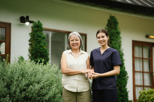 Professional caregiver assisting a senior woman during an outdoor walk, promoting mobility, balance, confidence, and independent aging.