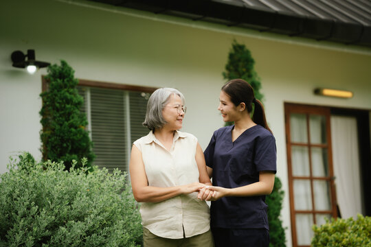 Professional caregiver assisting a senior woman during an outdoor walk, promoting mobility, balance, confidence, and independent aging.