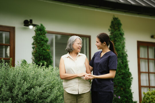Professional caregiver assisting a senior woman during an outdoor walk, promoting mobility, balance, confidence, and independent aging.