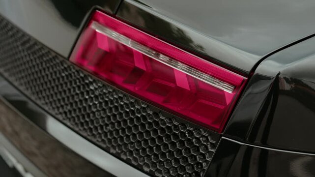 Description:
Close up of Lamborghini red taillight and mesh grille on black car